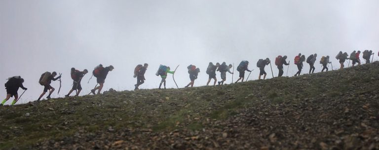 Senderistes a l'horitzó entre la boira. Travessa de muntanya per a joves Naturactiva